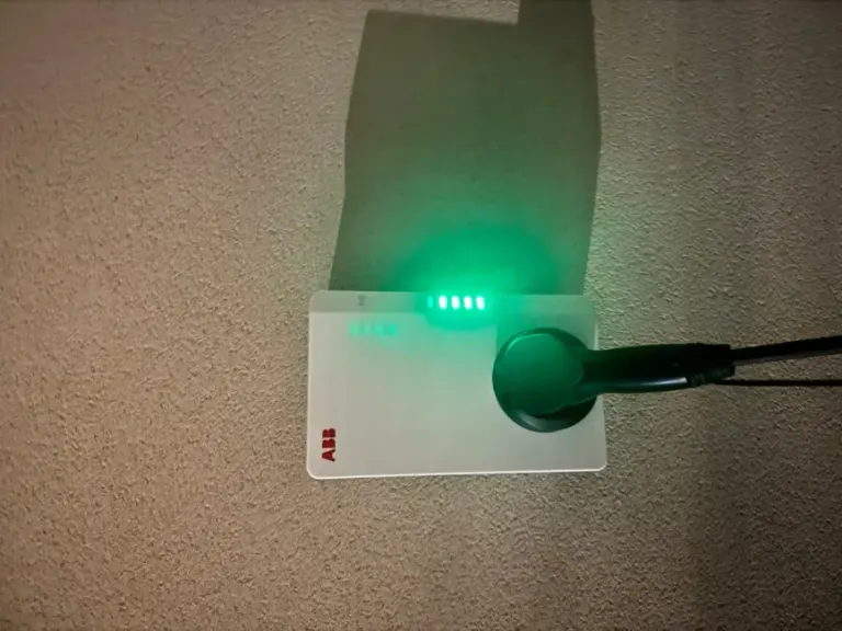 Borne de recharge en fonctionnement sur un parking, voyant vert de charge allumé