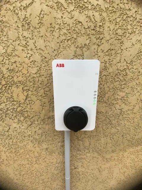Wallbox blanche posée d'aplomb sur la façade d'une maison, cheminement de câble soigné